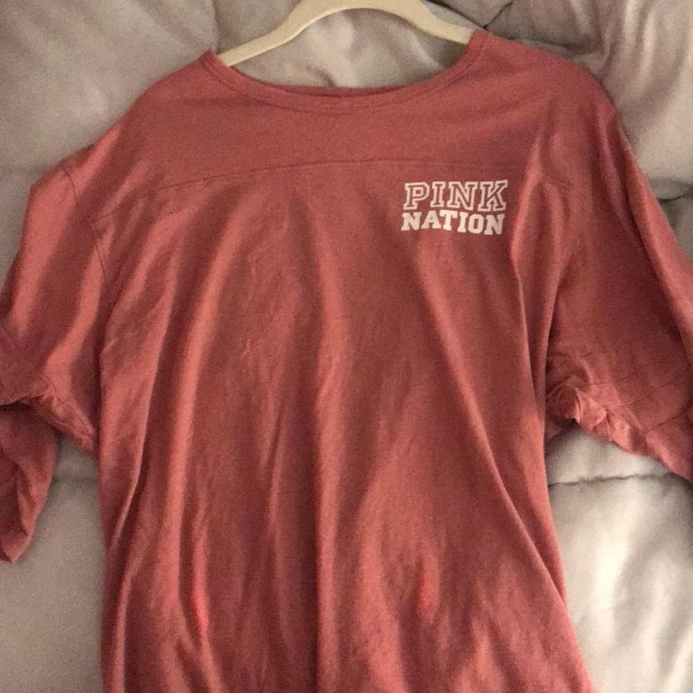 a long PINK shirt that has cropped sleeves